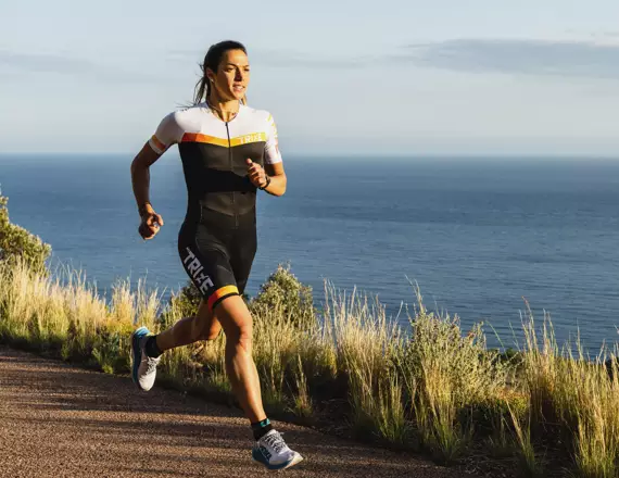 Charlotte Morel courant au bord de la mer et utilisant l'app Openrunner